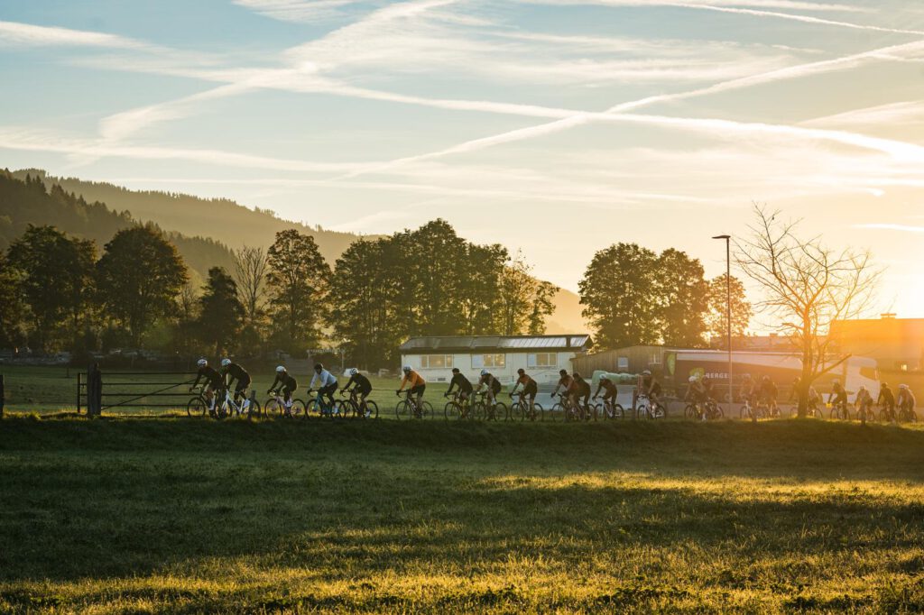 Gruppe von Radfahrern bei Sonnenaufgang auf Landstraße